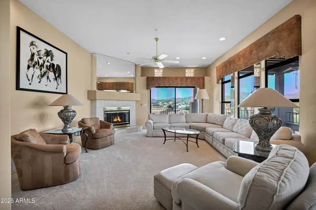 a living room with furniture a fireplace and a chandelier