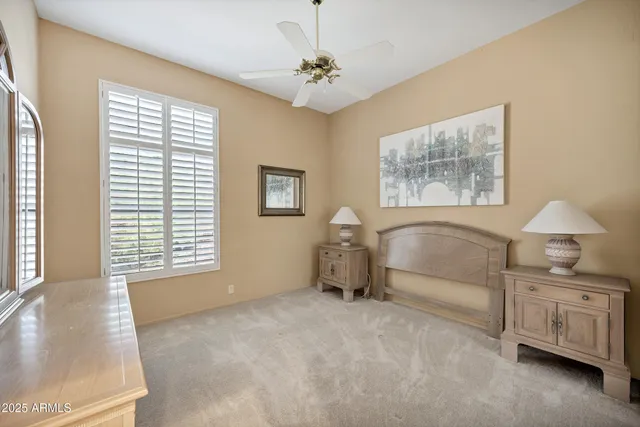 a spacious bedroom with a bed a dresser and next to a window