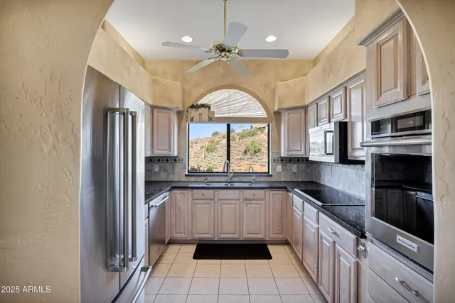 a kitchen with stainless steel appliances granite countertop a refrigerator and a sink