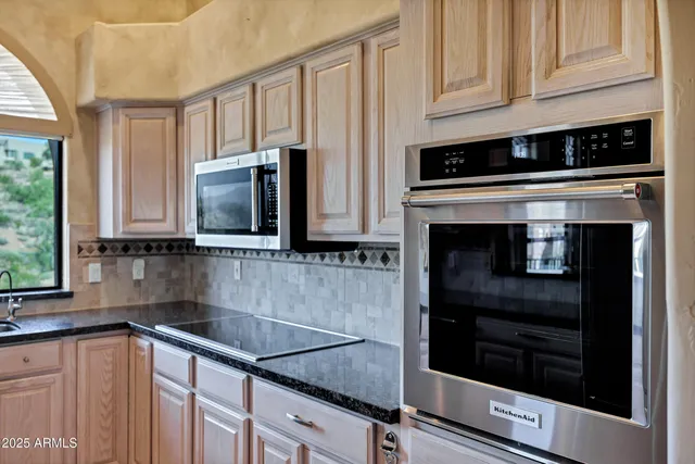 a kitchen with granite countertop white cabinets and stainless steel appliances