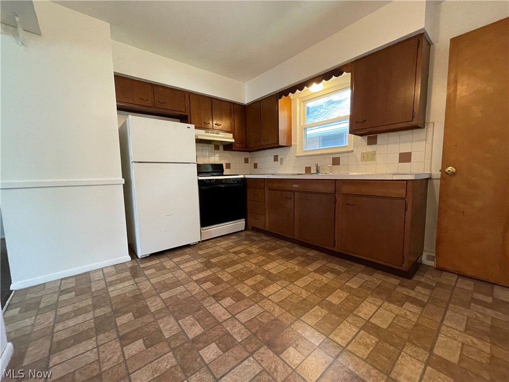 939 Nevin Street Akron, OH 44310 - Photo 15 of 23 Unit A Kitchen with backsplash, white appliances, and sink