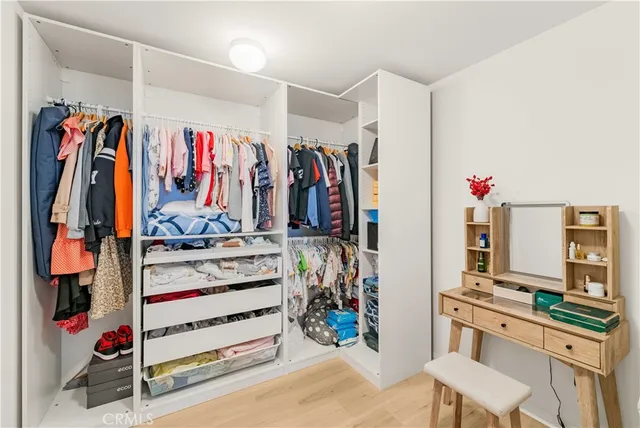 a view of walk in closet with clothes