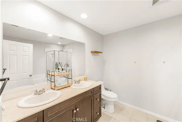 a bathroom with a granite countertop sink a toilet and a mirror