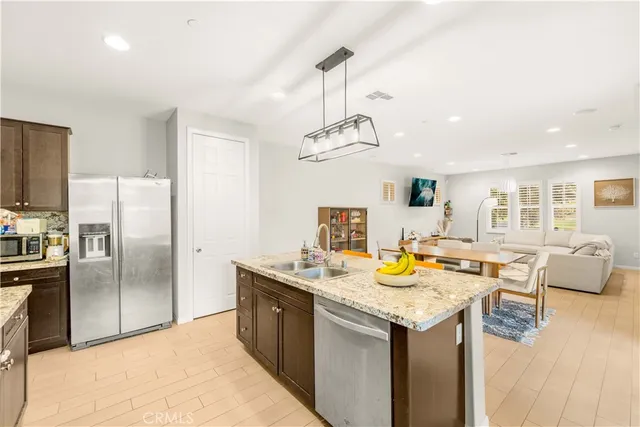a kitchen with a stove a refrigerator and living room view