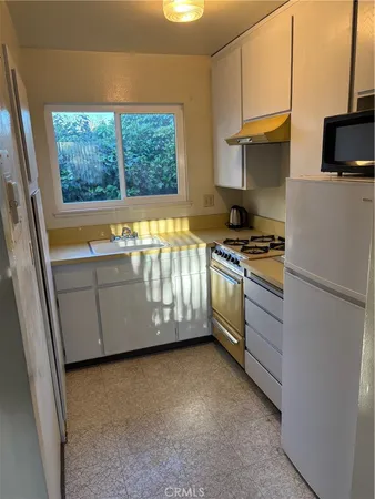 a kitchen with a stove a sink and a refrigerator