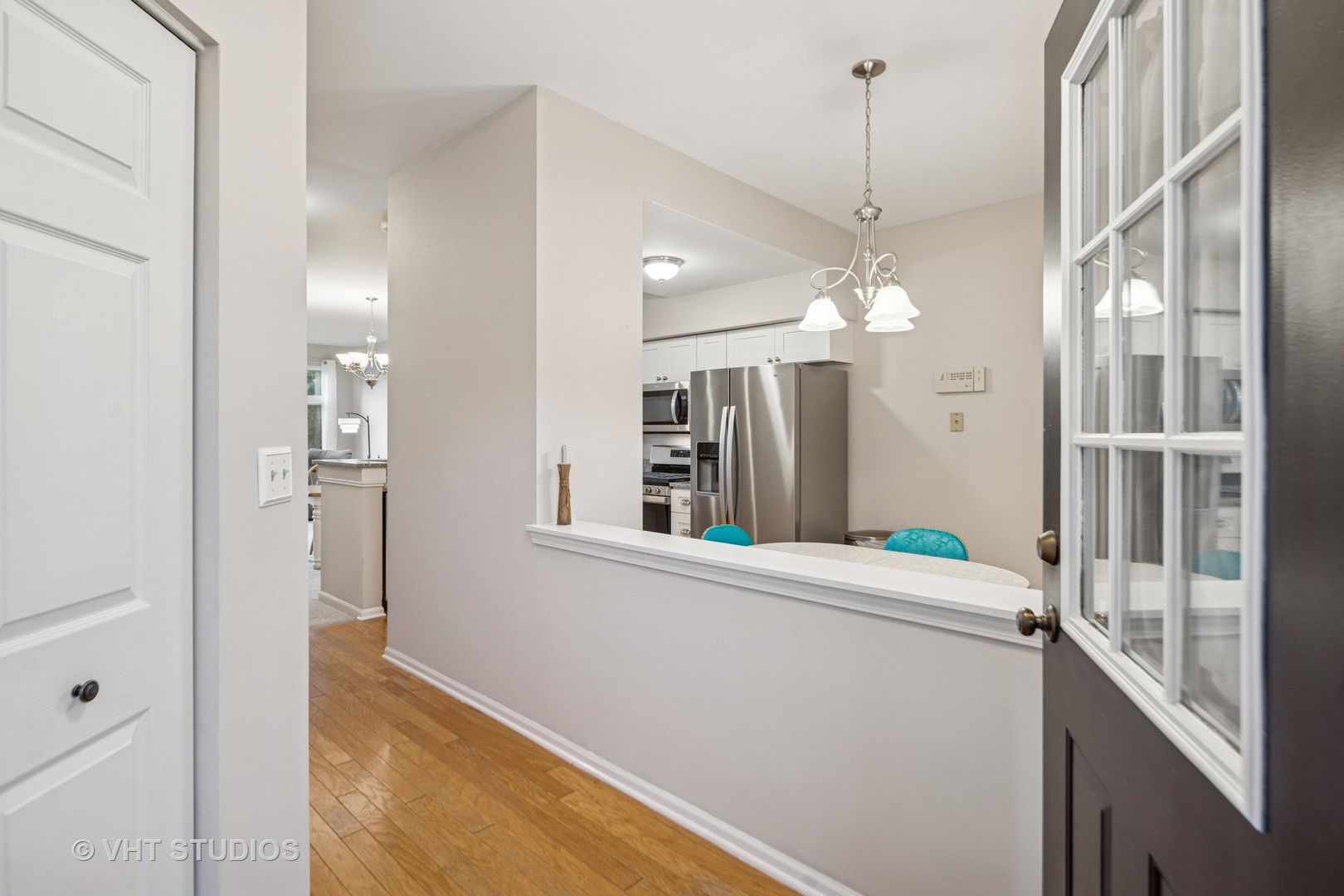 8291 Ripple Ridge, Unit 8291 Darien, IL 60561 - Photo 4 of 23 a view of a hallway with granite countertop a dining table chairs and a chandelier