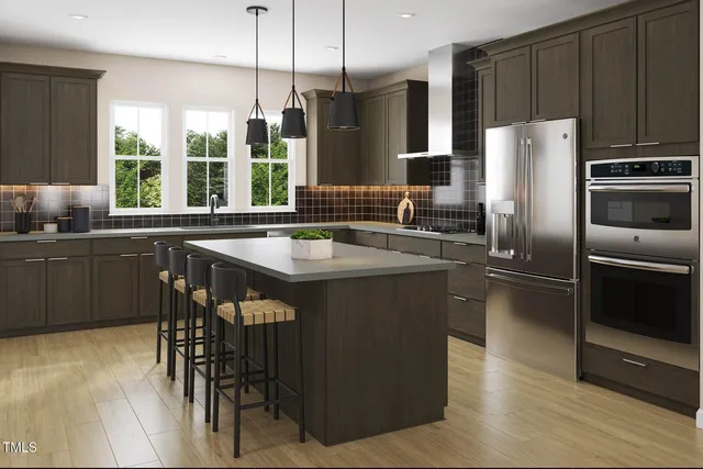 a kitchen with stainless steel appliances granite countertop a sink and a refrigerator