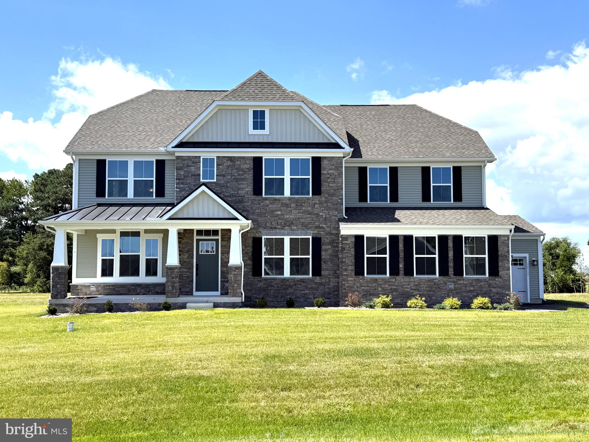 14566 Workman Circle Milton, DE 19968 - Photo 1 of 15 a front view of a house with a yard table and chairs