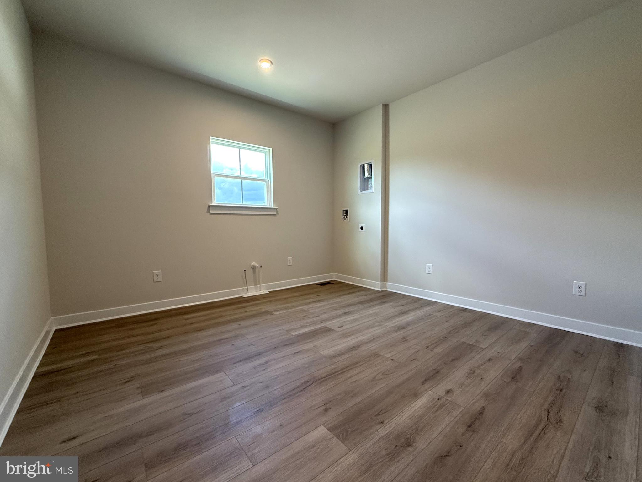 14566 Workman Circle Milton, DE 19968 - Photo 7 of 15 a view of an empty room with wooden floor and a window