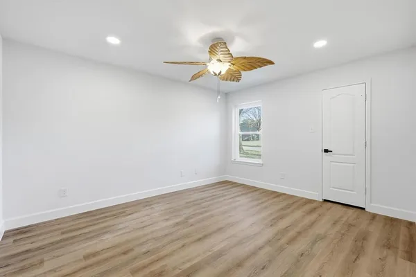 a bedroom with a bed a chandelier and a mirror on the dresser
