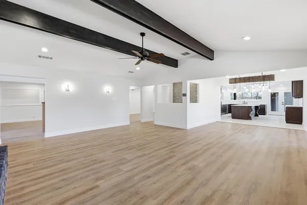 a view of empty room with wooden floor and window