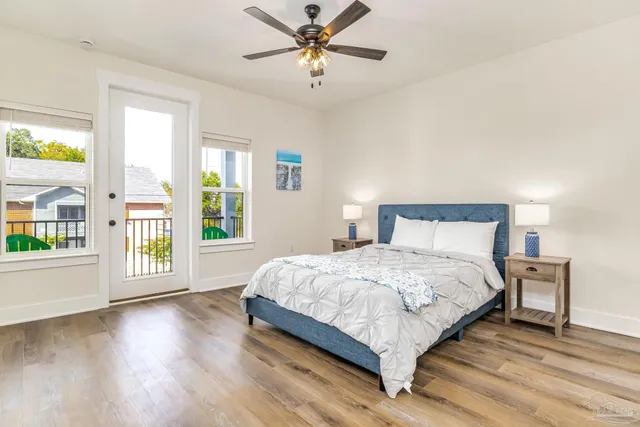 a large bedroom with a bed and wooden floor