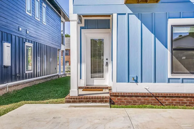 a view of a porch with a floor to ceiling window and front door