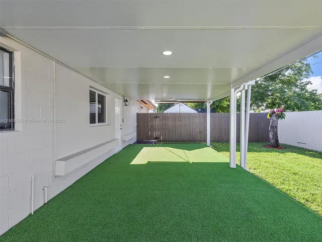 a view of backyard with table and chairs and wooden fence