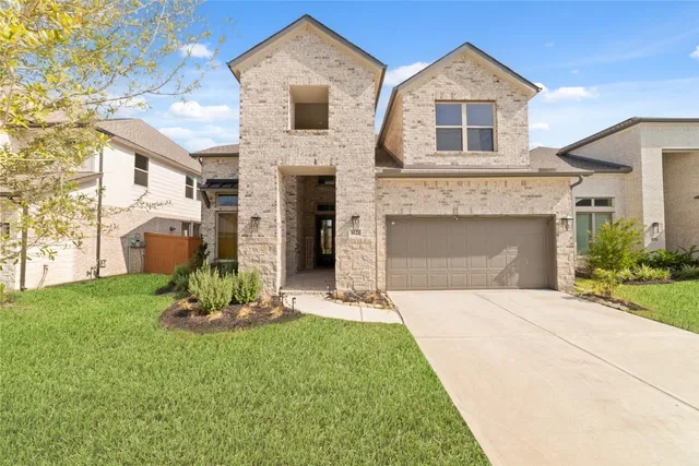 a front view of a house with a garden and yard