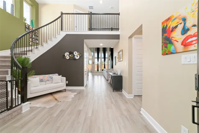 a view of a hallway with wooden floor and staircase