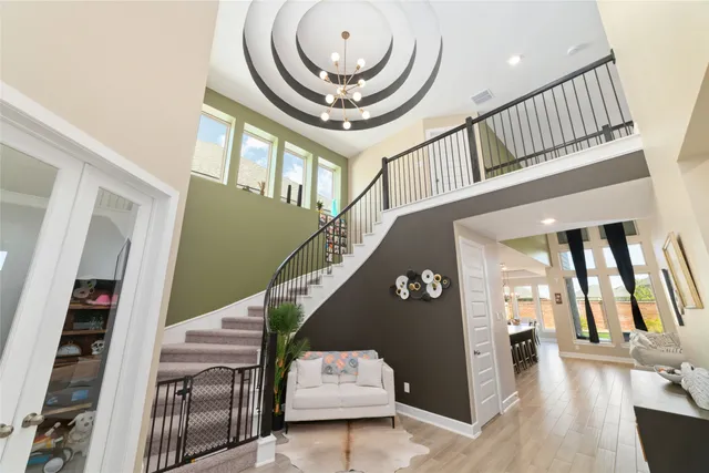 a view of staircase with lots of frames on wall and a chandelier