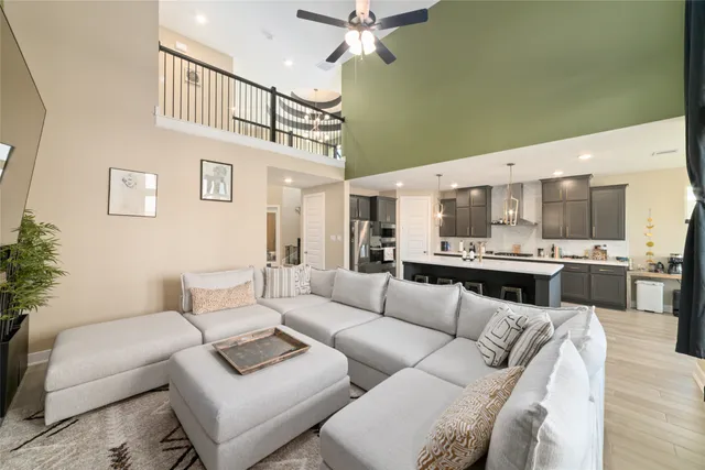 a living room with furniture kitchen view and a chandelier