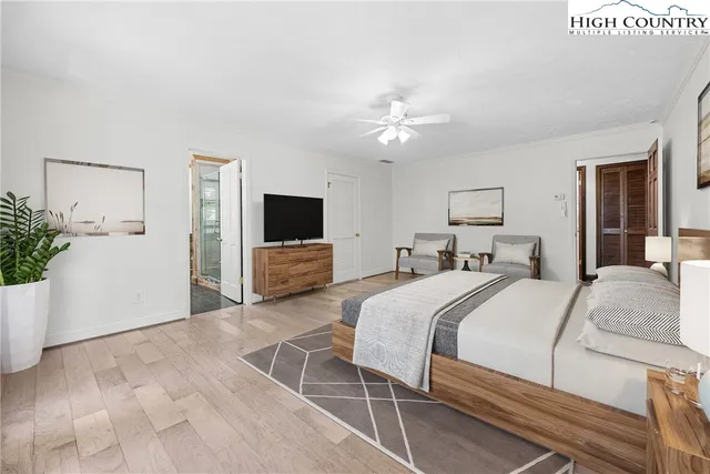 a spacious bedroom with a bed and a flat screen tv