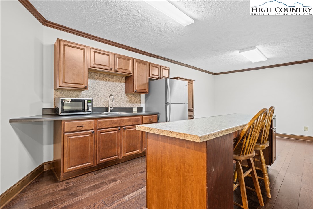 955 Dogwood Boone, NC 28607 - Photo 28 of 48 a kitchen with stainless steel appliances granite countertop a refrigerator a sink dishwasher a stove with white cabinets and wooden floor