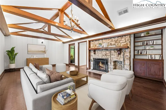 a living room with furniture a fireplace and wooden floor