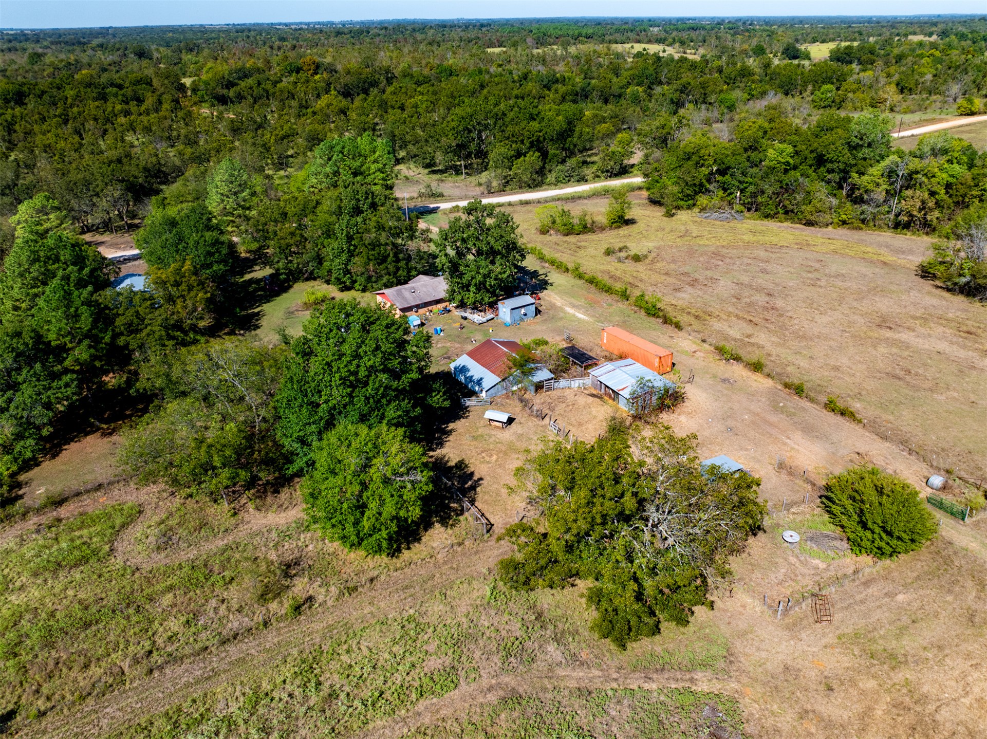 1599 North 4010 Road Boswell, OK 74727 - Photo 28 of 57 Expansive property featuring multiple structures, mature trees, and a dirt road