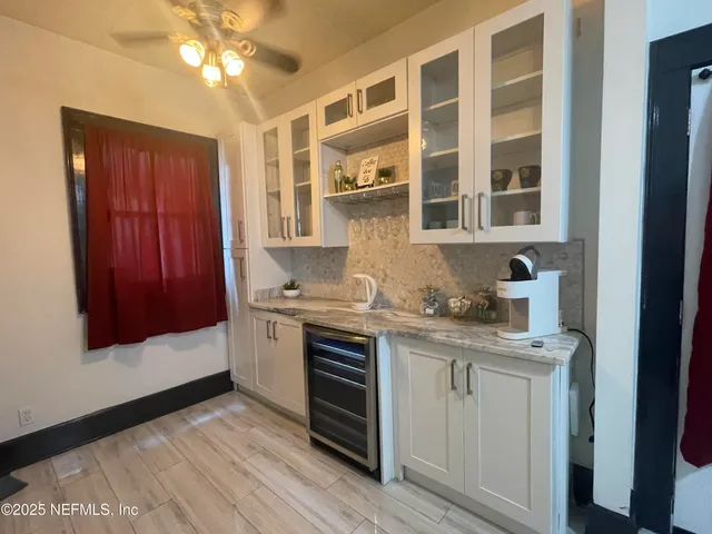a kitchen with stainless steel appliances granite countertop white cabinets and window