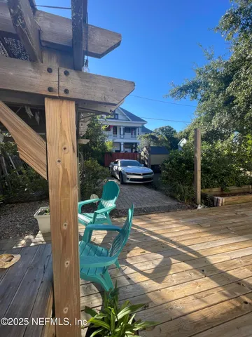 a view of a patio with table and chairs with wooden floor and fence