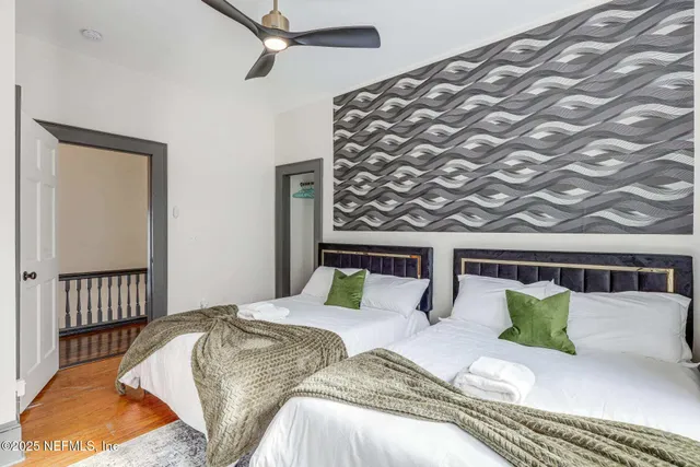 a bedroom with a bed and wooden floor