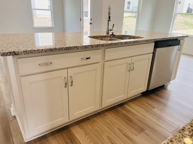 a kitchen with granite countertop white cabinets and white appliances