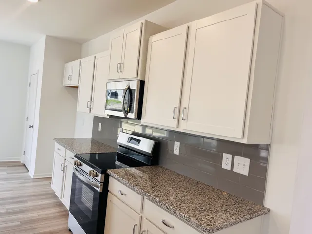 a kitchen with stainless steel appliances granite countertop a refrigerator sink and stove