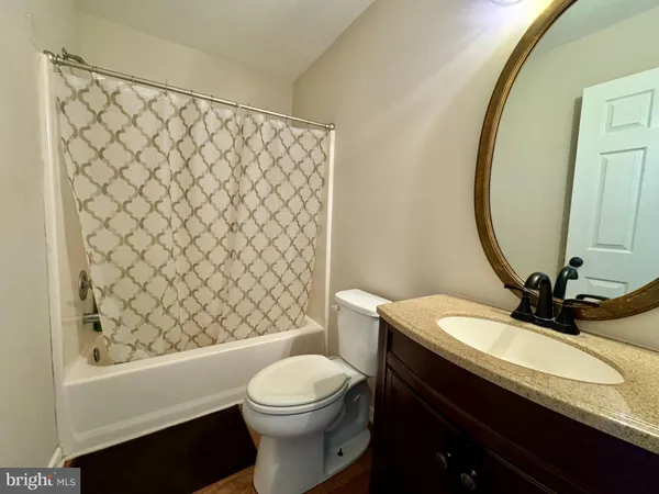 a bathroom with a sink a toilet and shower curtain