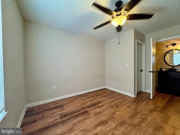 a view of empty room with a ceiling fan and wooden floor