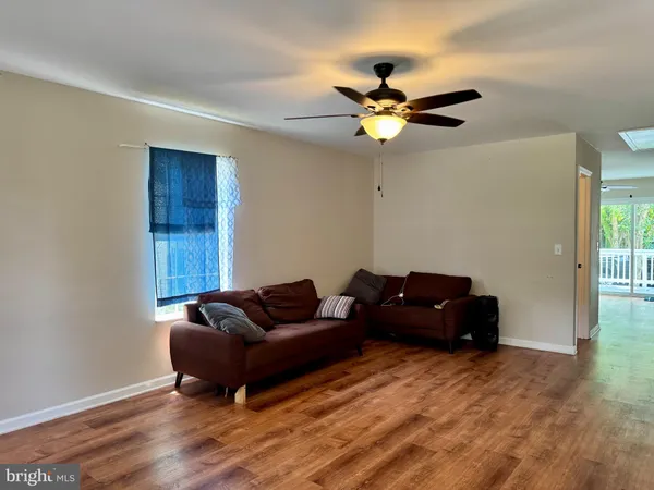 a living room with furniture and a ceiling fan
