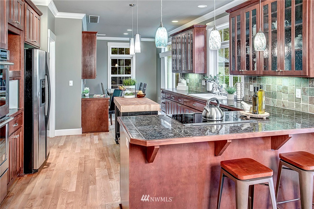 1101 North 27th Place Renton, WA 98056 - Photo 11 of 28 a kitchen with stainless steel appliances granite countertop a sink and a refrigerator