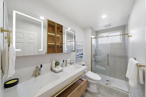 a bathroom with a sink a toilet and shower