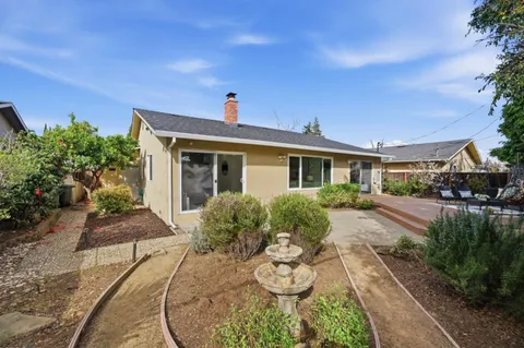 a view of a house with backyard and sitting area