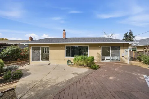 a front view of a house with a yard and potted plants