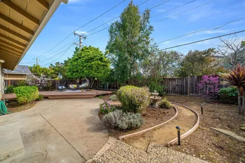a view of a tables and chairs in back yard of the house