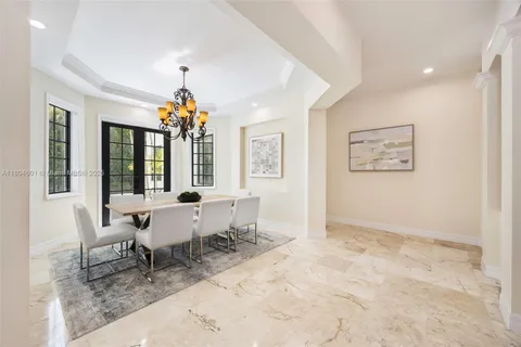 a dining room with wooden floor and a chandelier
