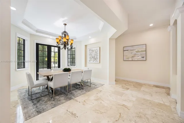 a dining room with wooden floor and a chandelier