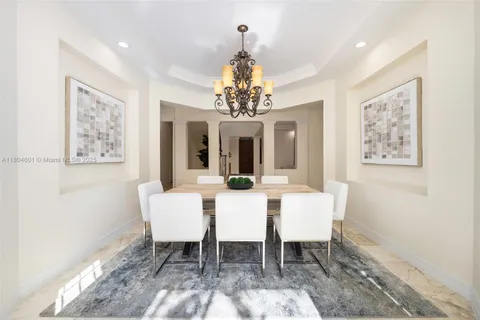 a view of a dining room with furniture and a chandelier