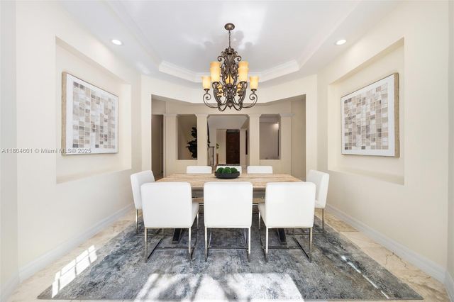 a view of a dining room with furniture and a chandelier