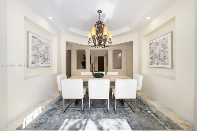 a view of a dining room with furniture and a chandelier