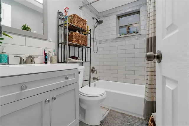 a bathroom with a bathtub sink vanity mirror and toilet