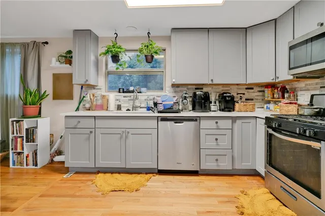 a kitchen with stainless steel appliances a sink stove and cabinets