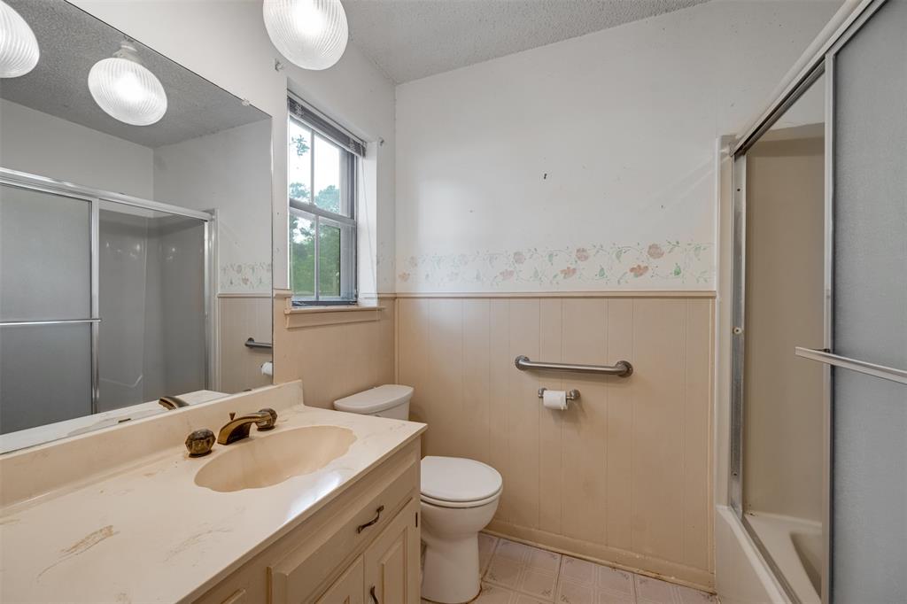 8798 Hill N Dale Road Tyler, TX 75709 - Photo 21 of 31 Bathroom vanity with an integrated sink, dual light fixtures, a large wall mirror, and a window providing natural light