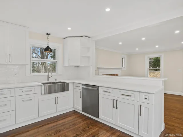 a kitchen with white cabinets and sink