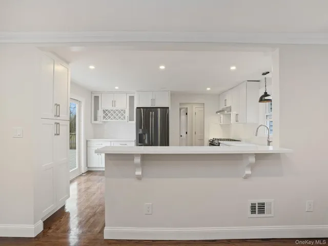 a large white kitchen with wooden floor
