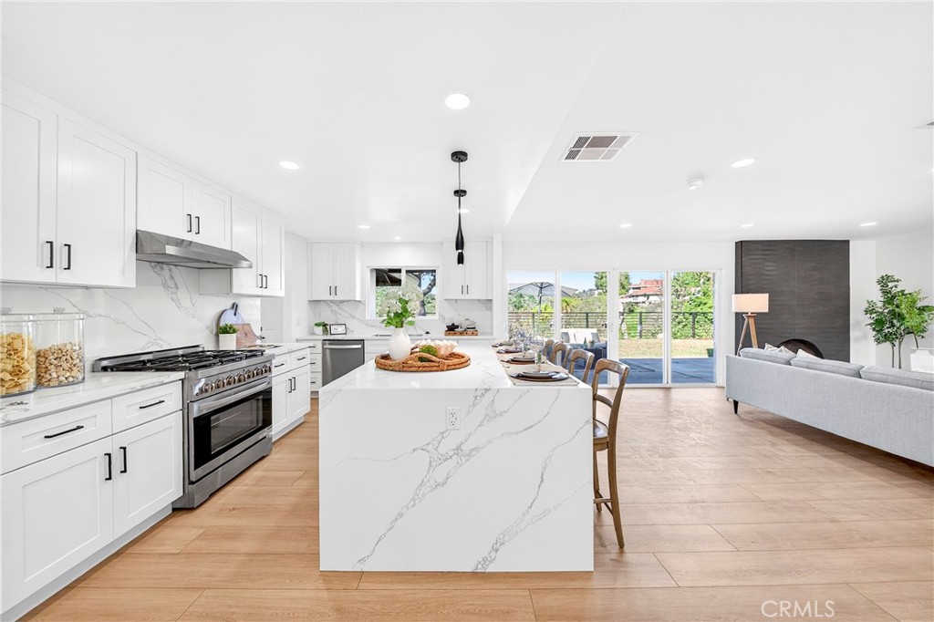 930 Rancho Circle Fullerton, CA 92835 - Photo 17 of 57 a kitchen with stainless steel appliances kitchen island granite countertop a stove a sink and white cabinets